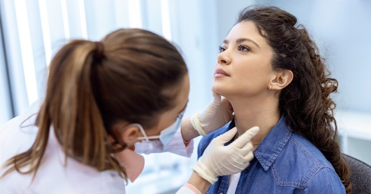 Doctor checking patient's thyroid